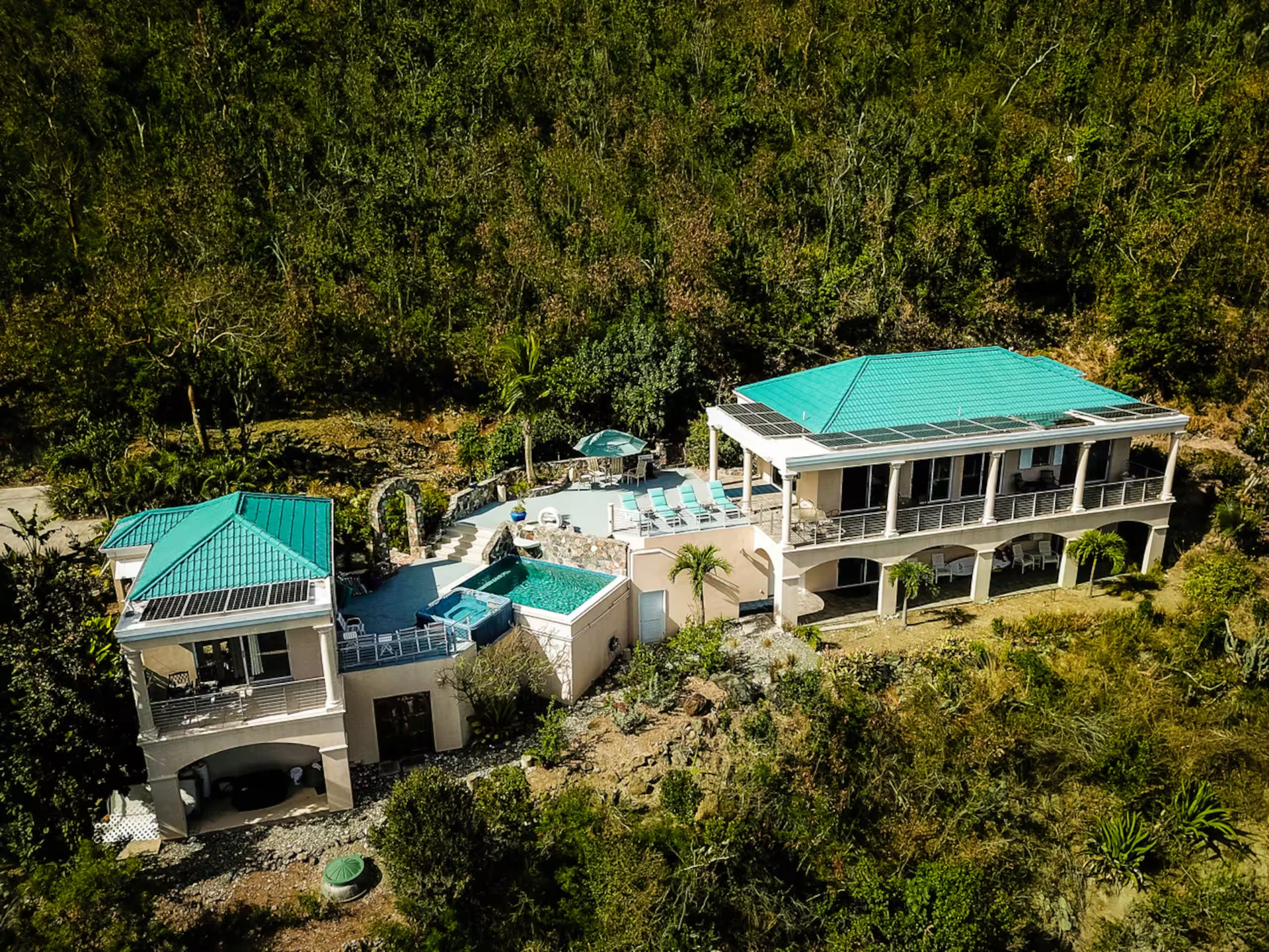 Aerial view of Sanctuary set into the green hillside above the sea