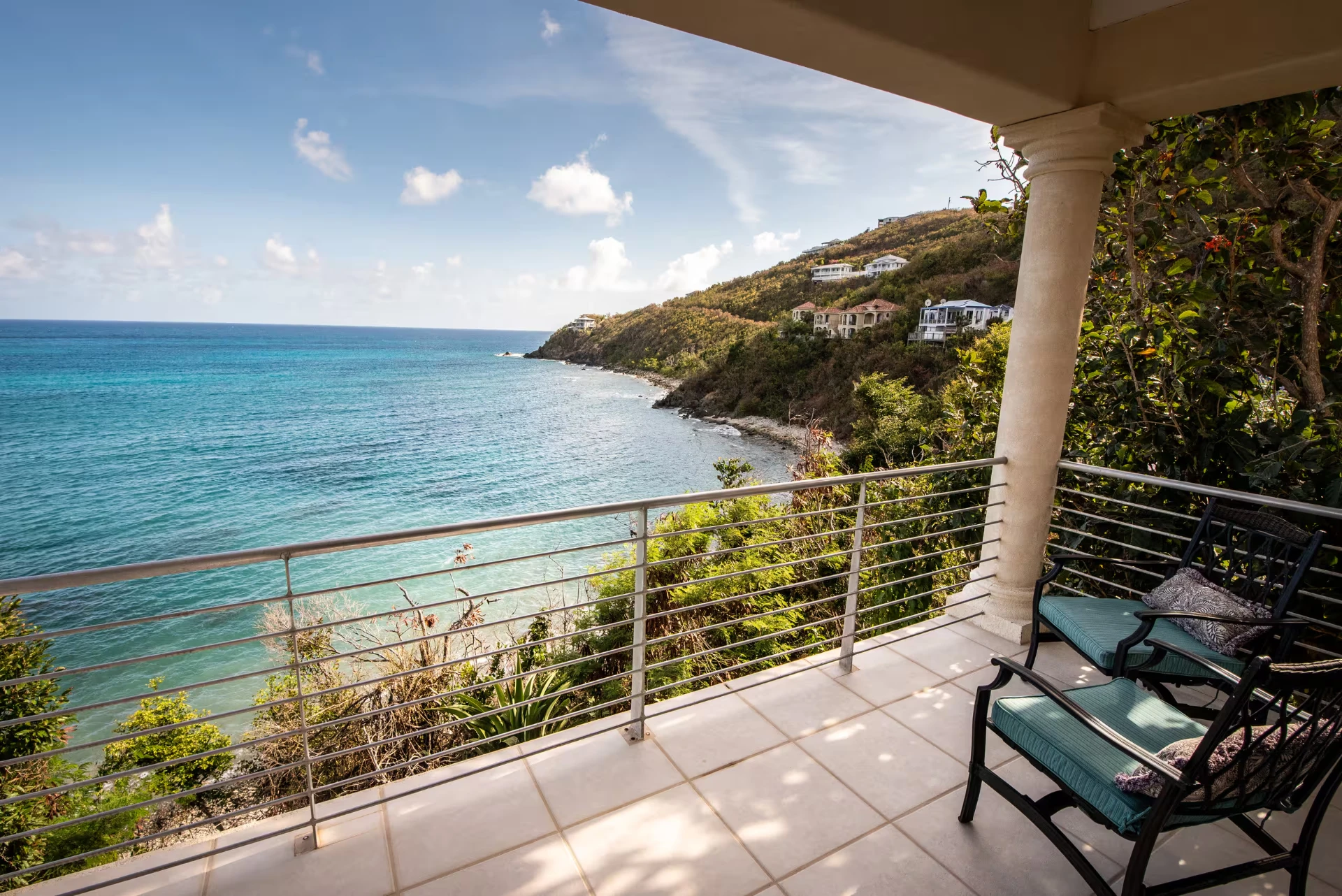 Private balcony off the upper guest suite with lounge seating overlooking the coastline