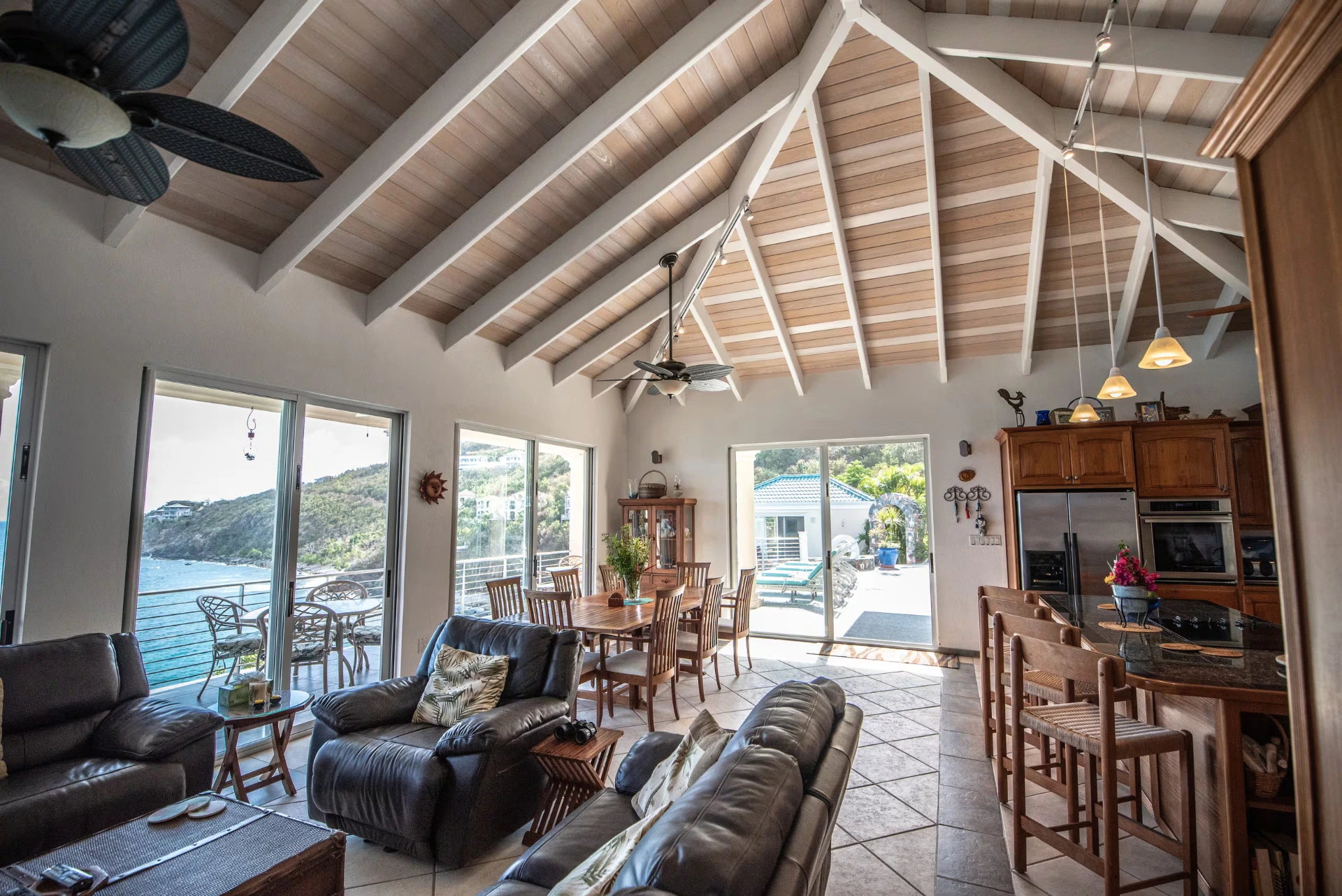 Great room with vaulted wood ceiling opening to the dining area and sea-view deck