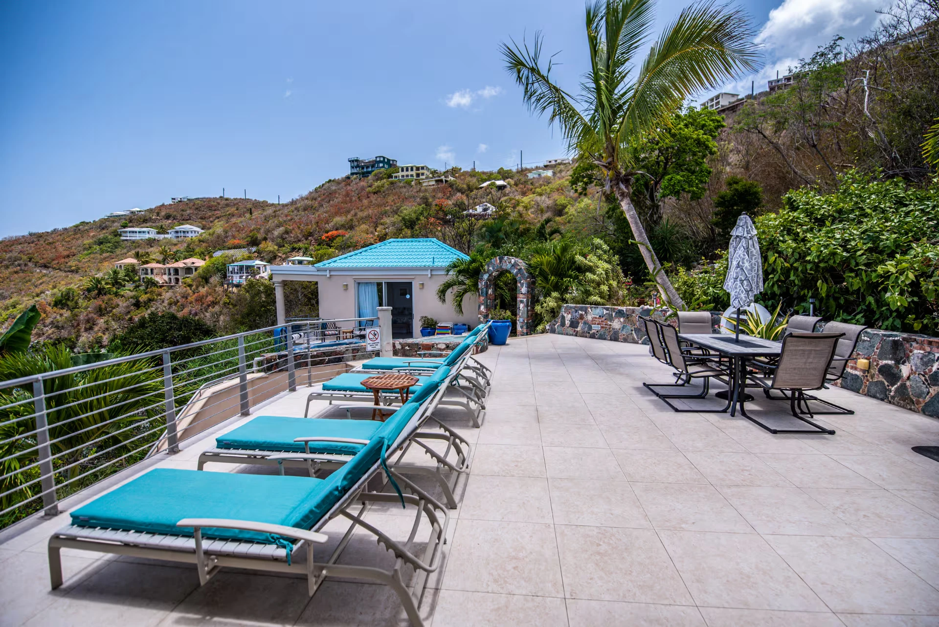 Row of turquoise loungers and an outdoor dining table on the sun deck